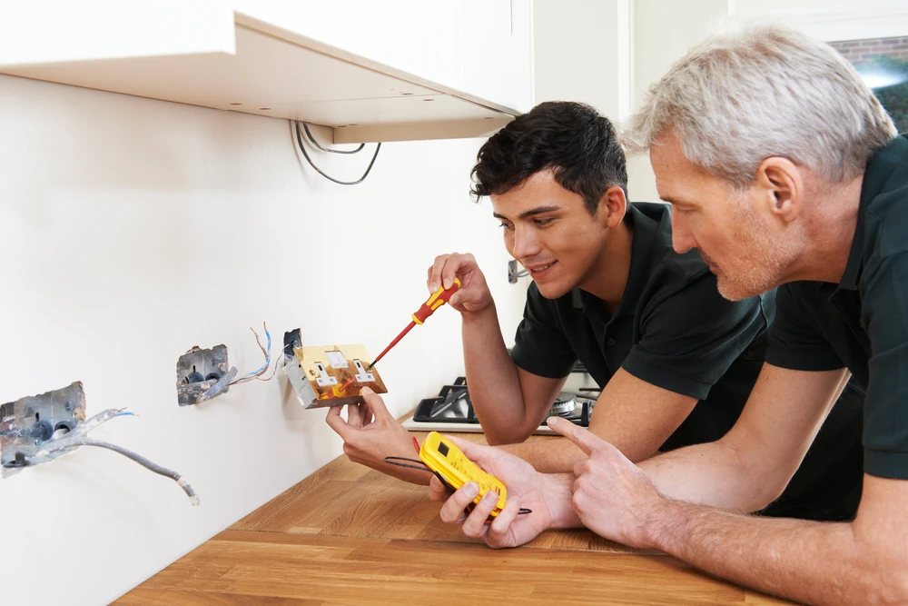 Électricien Avec Apprentis Travaillant Dans Une Nouvelle Maison