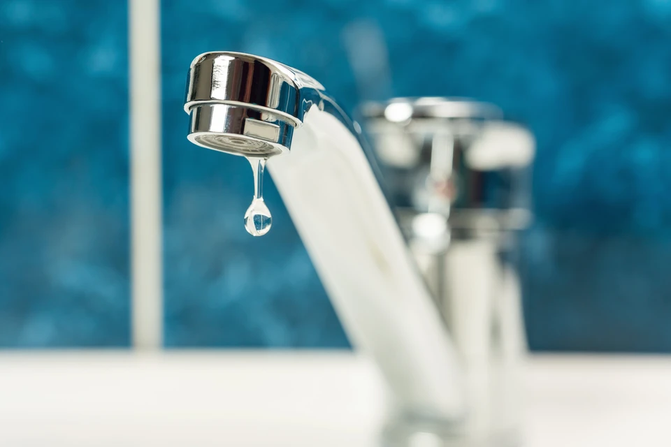 Intérieur domestique avec robinet de cuisine ou salle de bain en chrome présentant une fuite d'eau