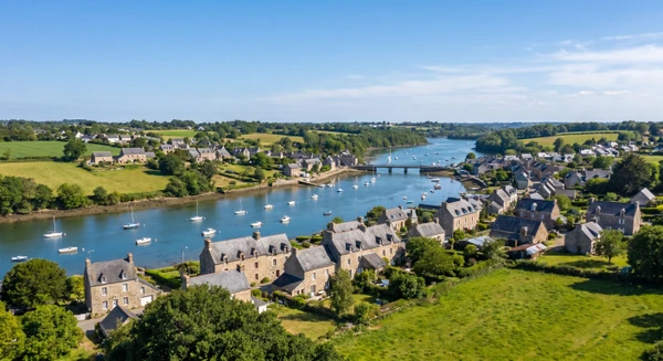 Photographie aérienne ou perspective paysagère de Pleudihen-sur-Rance montrant le village et ses environs avec la Rance visible, captant l'essence du territoire côtier breton que PC ELEC dessert. Image doit être une photographie réelle professionnelle de jour, claire et bien cadrée, mettant en avant les caractéristiques visuelles distinctives du village et de son environnement naturel.