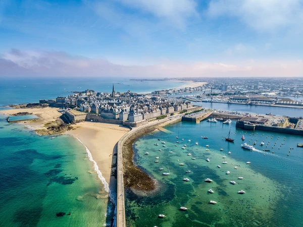 Vue aérienne ou perspective de la baie de Saint-Malo avec ses remparts caractéristiques et la mer, montrant l'environnement côtier breton que PC ELEC dessert. L'image doit être une photographie réelle, professionnelle, captant l'essence de Saint-Malo comme destination emblématique du secteur d'intervention.